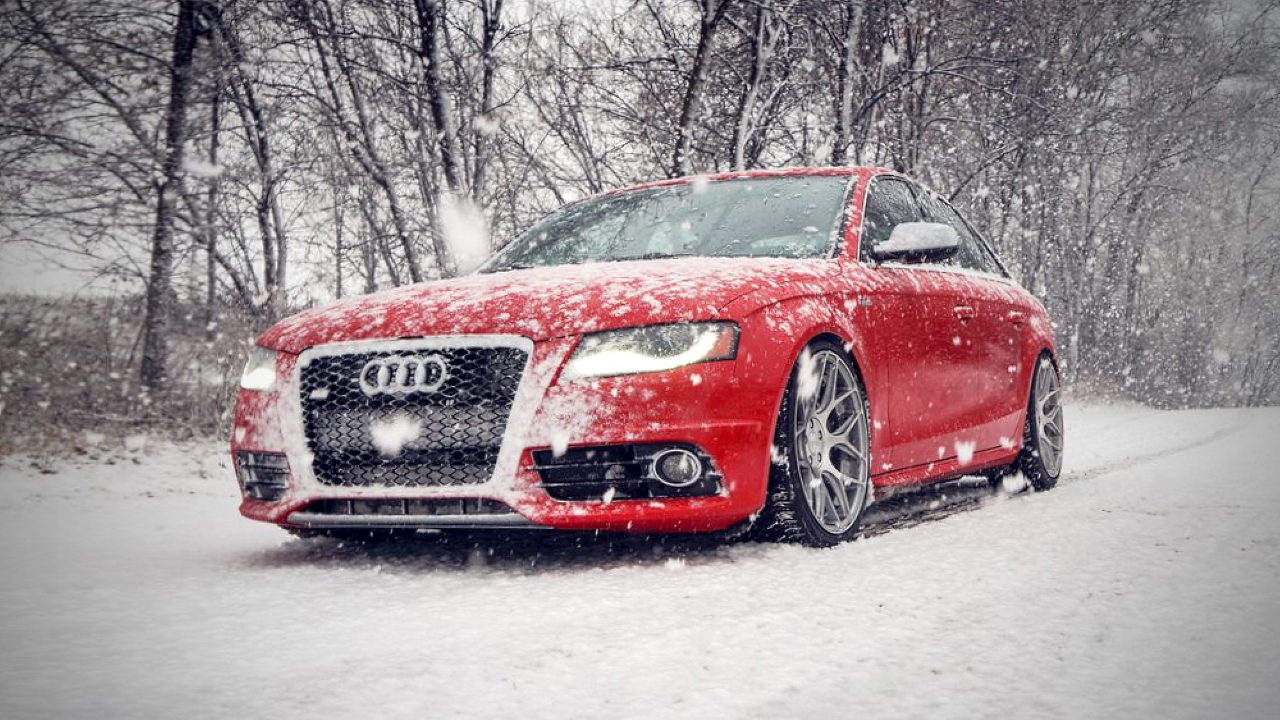 Автомобиль Audi едет по заснеженной дороге. 